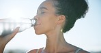 Happy woman, drinking water and relax in nature, fitness or natural nutrition after outdoor workout or exercise. Thirsty female person or mineral liquid on break or rest from cardio in sustainability