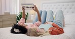 Friends relax with tablet to scroll on website for a movie or film choice lying on bed together at home. Technology, decision or people on internet search for ecommerce online shopping on app screen