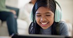 Girl, headphones and tablet for e learning, video call and online education on streaming platform. Young child from Indonesia listening to music, funny games and digital tech or home school on floor