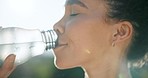 Happy woman, face and drinking water in nature, relax or fitness in natural nutrition, outdoor workout or exercise. Thirsty female person with mineral liquid on break after training in sustainability