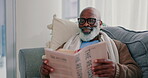 Smile, mature black man and reading book in home on living room sofa. Happy, novel and African person in lounge to relax, study literature and knowledge of fantasy story in retirement hobby in house