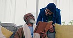 Conversation, notebook and man with his senior father on sofa in living room for journaling. Discussion, planning and young African male person talking to elderly dad writing notes in lounge at home.