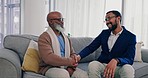 Father, son smile and handshake in home with bonding, care and love of African family together. Senior man, dad and support on a living room couch with conversation and communication on a lounge sofa