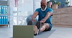 Senior man, stretching and exercise on laptop in online class, virtual training and fitness support at home. Happy elderly person in pilates, yoga workout and legs muscle in video call on computer