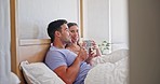 Conversation, coffee and couple in bed together talking, bonding and relaxing in apartment. Happy, smile and young man and woman speaking, laughing and drinking a latte in the bedroom at modern home.