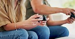 Hands, competition and a couple with games on the sofa for playing together in a house. Happy, fun and a man, woman or people with a console for tv gaming or winning on the living room couch