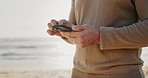 Phone, hands and man at a beach for travel, location and and internet, search or tracking in nature. Smartphone, app and guy at sea typing for social media, blog or checking web for chauffeur service