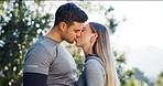 Fitness, couple and kiss in forest with love, romance or relax after hiking, running or workout in nature. Exercise, break and man with woman in park kissing, bond or passion in nature after training