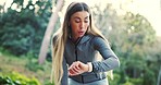Fitness, woman and runner check time in nature for exercise, workout or training goals, marathon and outdoor journey. Tired person breathing and running with smartwatch, challenge and focus in forest