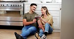 Couple on floor in kitchen with wine, toast and smile to celebrate love, marriage and happy home. Cheers with alcohol in glass, man and woman on ground to relax for conversation in apartment together