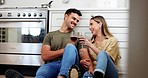 Couple on floor in kitchen with wine, cheers and smile to celebrate love, marriage and happy home. Toast with alcohol in glass, man and woman on ground to relax for conversation in apartment together