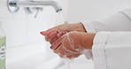 Person, water and washing hands in hygiene, cleaning or germ and bacteria removal in bathroom at home. Closeup of human in disinfection, soap or rinsing under tap for cleanliness, wash or skincare