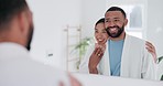 Love, hug and happy couple in the bathroom for health, wellness and morning routine together. Smile, mirror and interracial man and woman embracing before self care treatment at modern apartment.