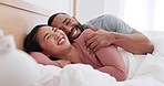 Happy couple, bed and morning wake up, laughing or joke in relax on holiday, weekend or break at home. Man and woman smile lying in bedroom happiness, humor or fun bonding or cuddle together at house