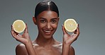 Beauty, skincare and happy woman in studio with lemon, natural cosmetics isolated on grey background. Makeup, organic vitamin c dermatology and skin care model with spa or salon fruit detox facial.