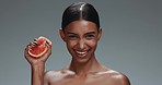 Woman, face and beauty with grapefruit, studio or squeeze juice with smile, wellness or skincare by dark background. Girl, model and cosmetic with fruit, diet or glow for facial aesthetic in portrait