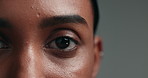 Eye, beauty and skincare with a woman on a gray background in studio closeup for cosmetics. Face, vision and natural care with a young person looking confident with her skin or facial treatment