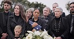 Funeral, cemetery and family with American flag for veteran for respect, ceremony and memorial service. Sad, depression and people by coffin in graveyard for military hero, army and soldier mourning