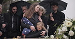 Funeral, family hug and sad people with grief support, goodbye service and mourning death at burial event. Kid child, mom embrace and group gathering together at coffin, casket and crying at ceremony