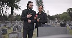 Sad, couple and mourning at tomb of cemetery, funeral and pay respect together outdoor. Death, grief and man and woman at graveyard by casket, empathy and interracial support to console at tombstone