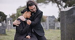 Sad couple, graveyard and hug in loss, grief or mourning together at funeral, tombstone or cemetery. Man holding woman in comfort, empathy or goodbye at memorial or burial service for death on grass