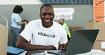 Man, volunteering and computer for online donation, community service and helping at NGO or nonprofit. Happy face of african person or volunteer on laptop, website charity and social media management