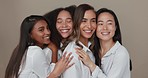 Women, group skincare and beauty with love, hug and support in diversity and inclusion on brown studio background. Friends, model or people smile together and kiss in dermatology, skin care or makeup