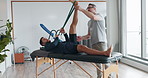 Physiotherapy, man and training the muscle in legs with a resistance band, equipment or healing exercise with therapist. Physical, rehabilitation and patient stretching with physiotherapist helping