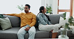 Unhappy, fight and couple angry on a couch together duo to infertility, argument and toxic relationship in a home. Conflict, divorce and man has problem with woman in a living room sofa for cheating