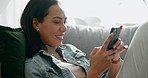 Woman, phone and and happy text in home with social media post, networking and online on a sofa. Mobile app, message and typing on a living room couch with digital entertainment and tech in house