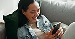 Woman, laugh and typing with phone on sofa, scroll social media or reading funny notification from home. Smartphone user, meme and search website, download digital app and mobile games in living room