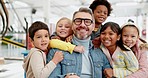 Children, teacher and portrait with a hug in classroom with love in education, learning and kids excited to be in school. Kids, students and support and care for man with a smile on face in class