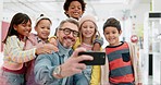 Teacher man, selfie and school kids with smile, classroom and happy with diversity, group and memory. Education, learning and mentor with photography, friends and development on social network app 