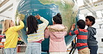 World, map and children learning with a globe in classroom, education or study geography in school with exited students. Kids, group and teaching students about planet, earth and countries on sphere