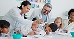 Experiment, chemistry and teachers with children in class for a test, study or research. Education, science and team of  professional scientists teaching kid students chemical reaction in school lab.