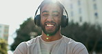Face, fitness and music with a sports man in the city for cardio training or marathon preparation. Portrait, smile and headphones with a happy young athlete in an urban town for a summer workout