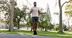 Cardio, outdoor and man skipping with a rope in park, forest or healthy fitness training in nature with exercise equipment. Athlete, jumping and workout warmup in morning for cardiovascular wellness