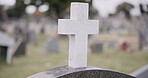 Funeral, graveyard and cross on tombstone for death ceremony, religion or memorial service. Catholic symbol, background or Christian sign on gravestone for mourning, burial or loss in public cemetery