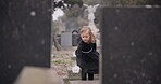 Flower, death or kid in cemetery for funeral. spiritual service or tombstone for respect in Christian religion. Mourning, sad or depressed girl child outside in graveyard for grief, loss or farewell