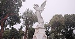 Funeral, graveyard and angel on tombstone for death ceremony, religion or memorial service. Statue symbol, background or Christian sign on gravestone for mourning, burial or loss in public cemetery