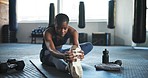 Fitness, gym and black woman on floor stretching legs for training, exercise and workout on yoga mat. Sports center, personal trainer and person do warm up for wellness, performance and flexibility
