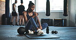 Tired, sweat and woman with towel at gym for exercise, fitness and break from cardio workout. Exhausted african lady breathing for recovery, performance challenge and training fatigue in health club