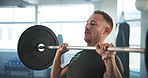 Man, fitness and weightlifting barbell in workout, exercise or training for muscle gain at indoor gym. Active male person, athlete or bodybuilder lifting heavy weight or bar in motivation or power
