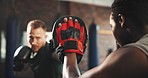 Sports trainer, man and boxer punch training, learning fighting skill or self defense exercise, practice or MMA fist impact. Gym hard work, fighter gloves and coach coaching boxing power development