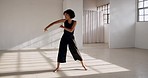 Dancing, performance and a woman with fitness in a creative art studio with energy and passion. African contemporary dancer practice for theater, sports and freedom with balance, exercise and talent