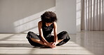 Stretching, back and woman in yoga or dancer relax sitting on floor or breathing in meditation, pose or mindfulness. Warm up, exercise and training movement to start fitness, workout or calm stretch