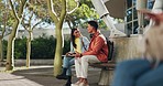 Outdoor, university campus and couple of friends with discussion and happy from education. Laughing, conversation and young people together on a park bench with communication and talking at college