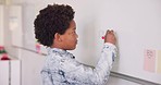 Math class, child at writing on board for education, learning and problem solving for skill development. Boy at whiteboard in classroom with solution, thinking and studying at school for knowledge.