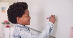 Math class, happy child at board for education, learning and problem solving for skill development. Boy writing on whiteboard in classroom with solution, thinking and smile at school for knowledge.