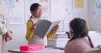 Child, reading and classroom with girl speaker, book and education at a school. Students, learning and notebook with development, knowledge and study work with story discussion of youth assessment